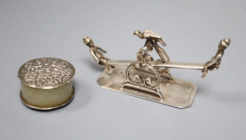 A Dutch white metal toy model seesaw group, 7cm and a white metal mounted thread waxer, 24mm.